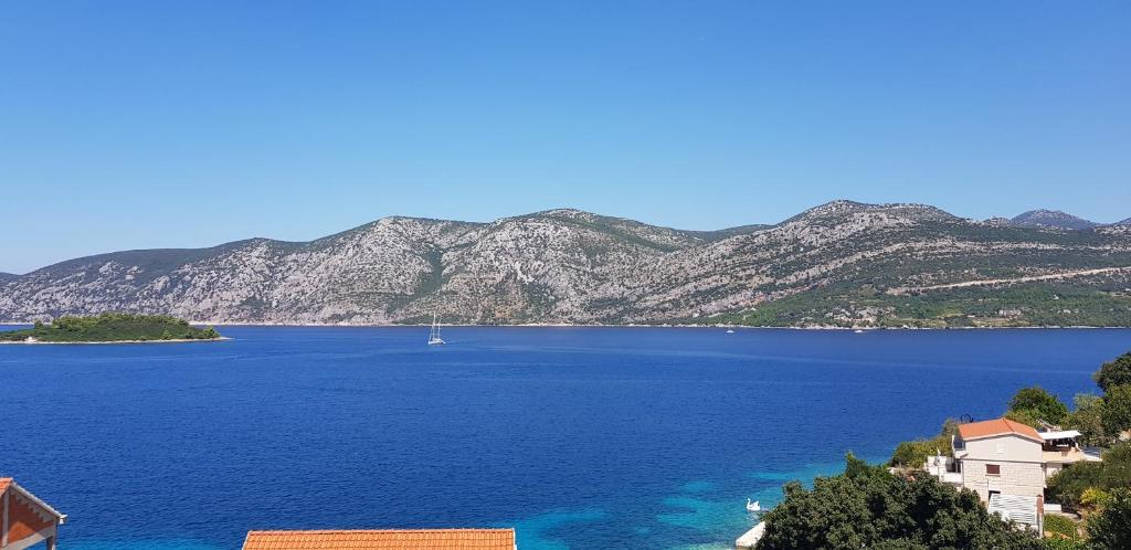 una vista de un gran cuerpo de agua con montañas en Luxury apartment Korcula - Villa Sunny Days en Korčula