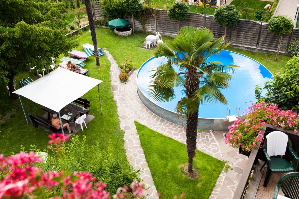 una vista aérea de una piscina en un patio con una palmera en Gasthaus Abram, en Ora - Auer