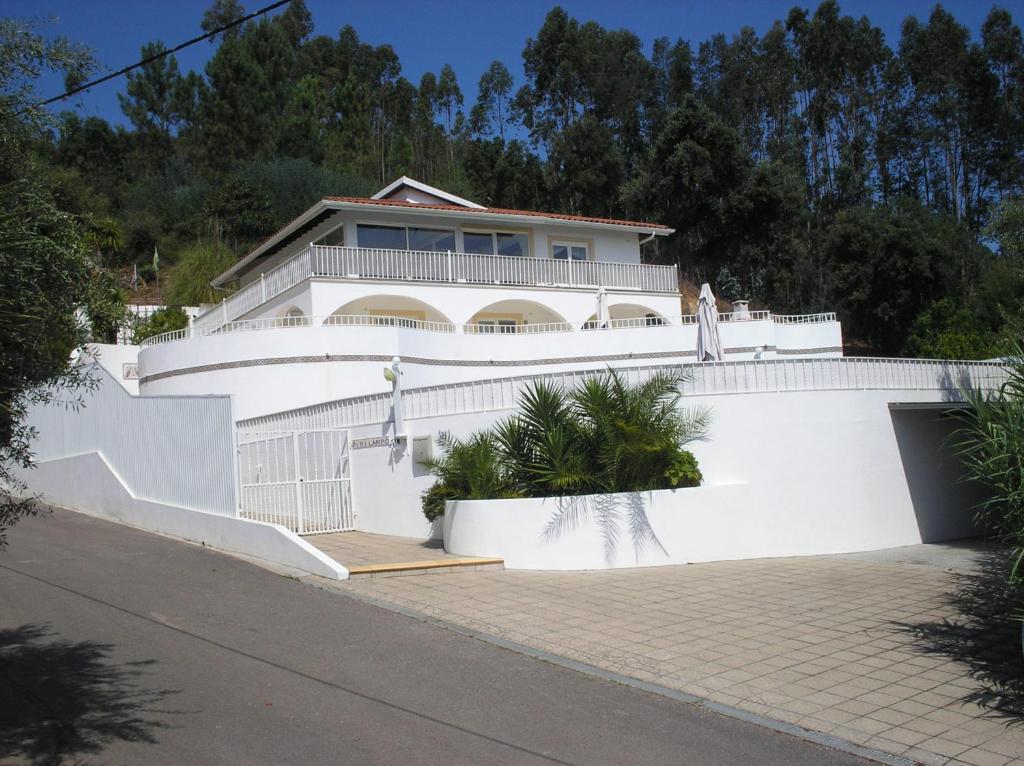 ein großes weißes Haus mit einem weißen Zaun in der Unterkunft Vivenda Pirilampo in Vila Nova de Poiares