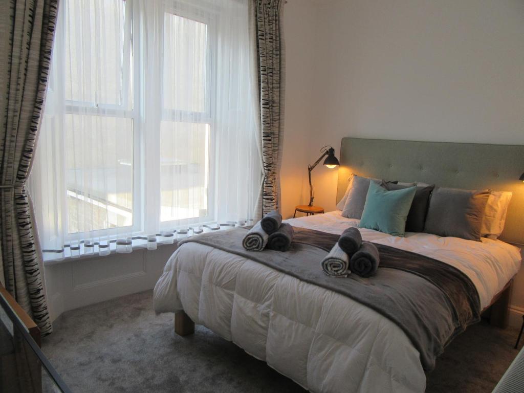 ein Schlafzimmer mit einem großen Bett mit Schuhen drauf in der Unterkunft Central Living Apartment in Weston-super-Mare