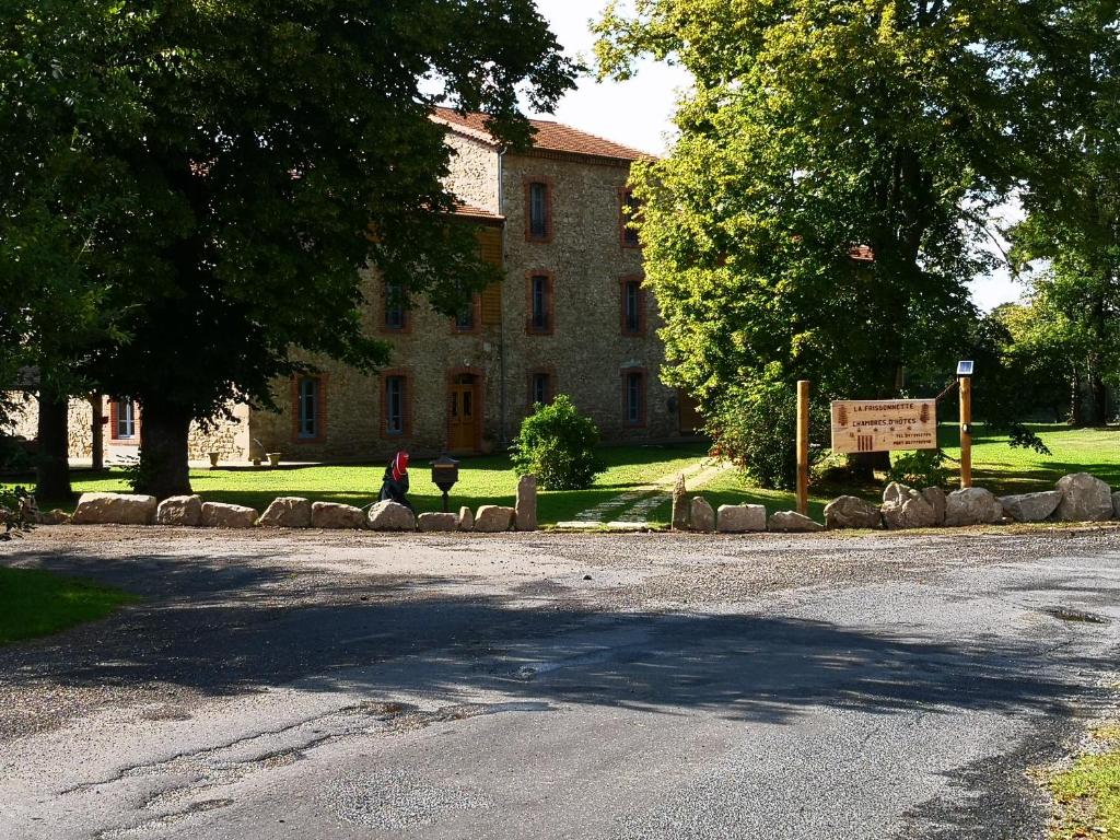 una persona está parada frente a un edificio en Les chambres d'hôtes de la Frissonnette en Auzelles