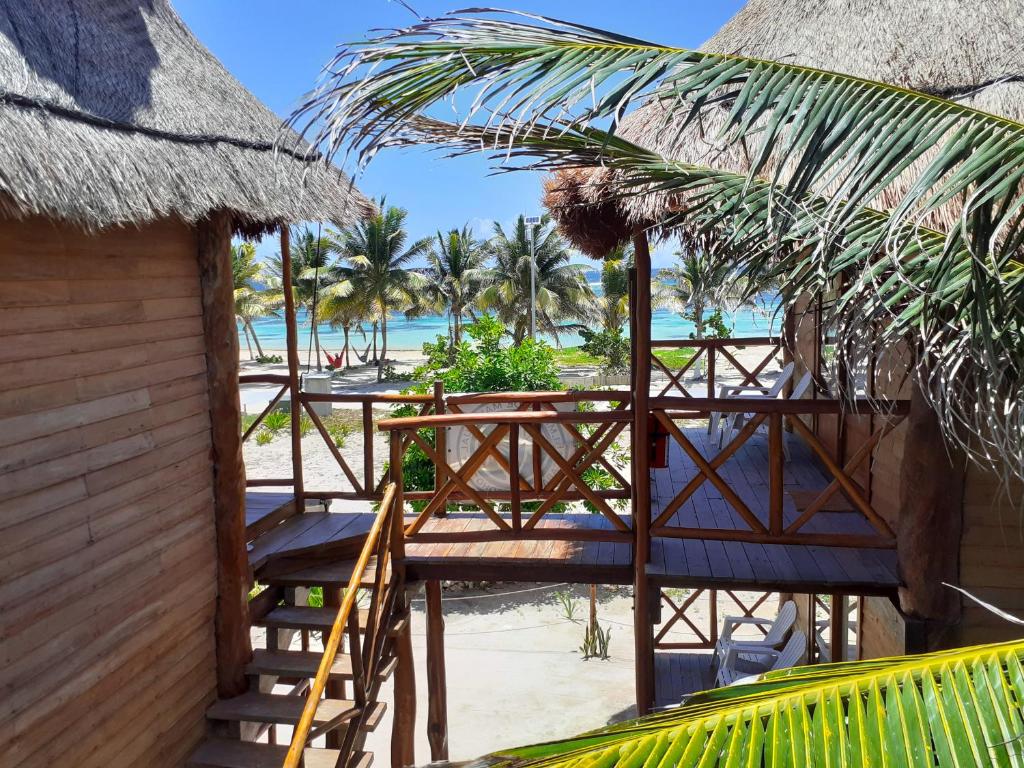 a resort with tables and chairs on the beach at Palmeras de Mahahual Cabañas in Mahahual