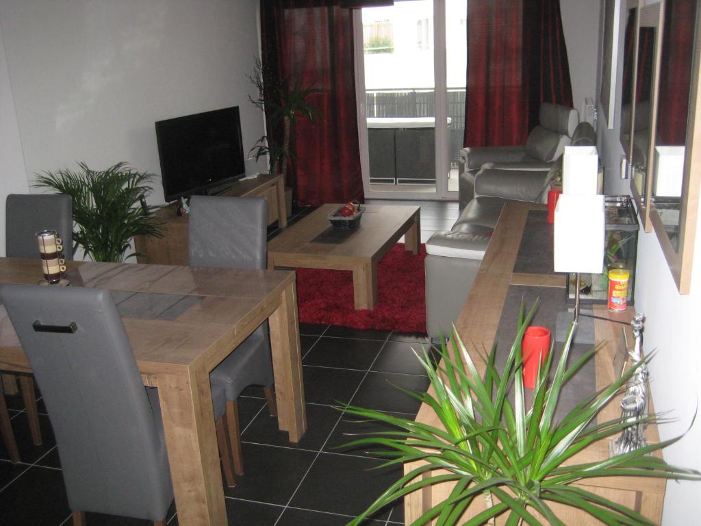 - un salon avec une table et un canapé dans l'établissement Beau T3 avec terrasse plein sud, à Montpellier