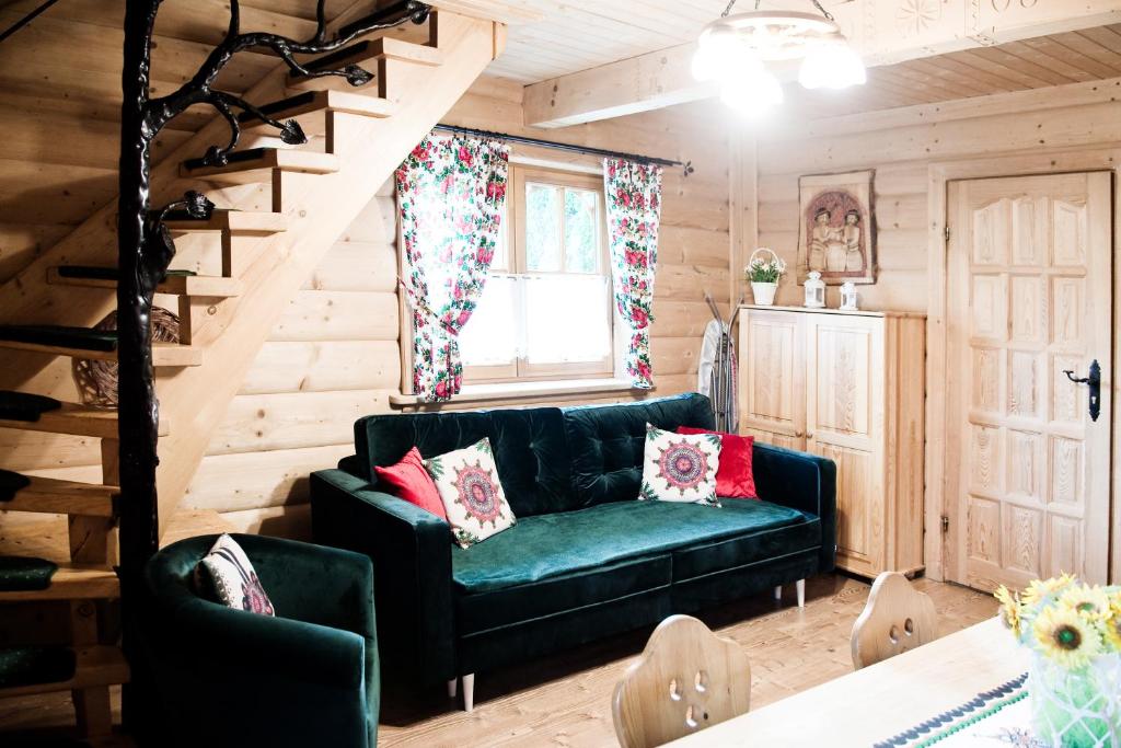 a living room with a green couch and a staircase at Domek Regionalny in Zakopane