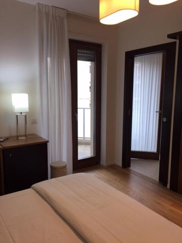 een slaapkamer met een bed, 2 ramen en een lamp bij B&B COJBA in Gravina in Puglia