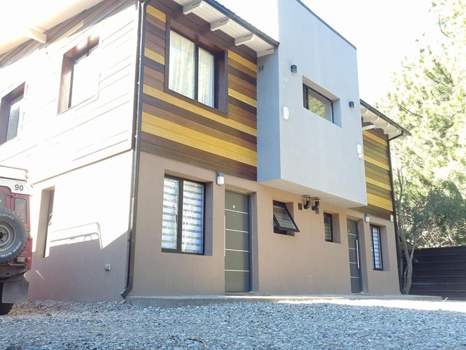 a house with a building with a driveway at Camino al Cerro Holiday Apartments in San Carlos de Bariloche