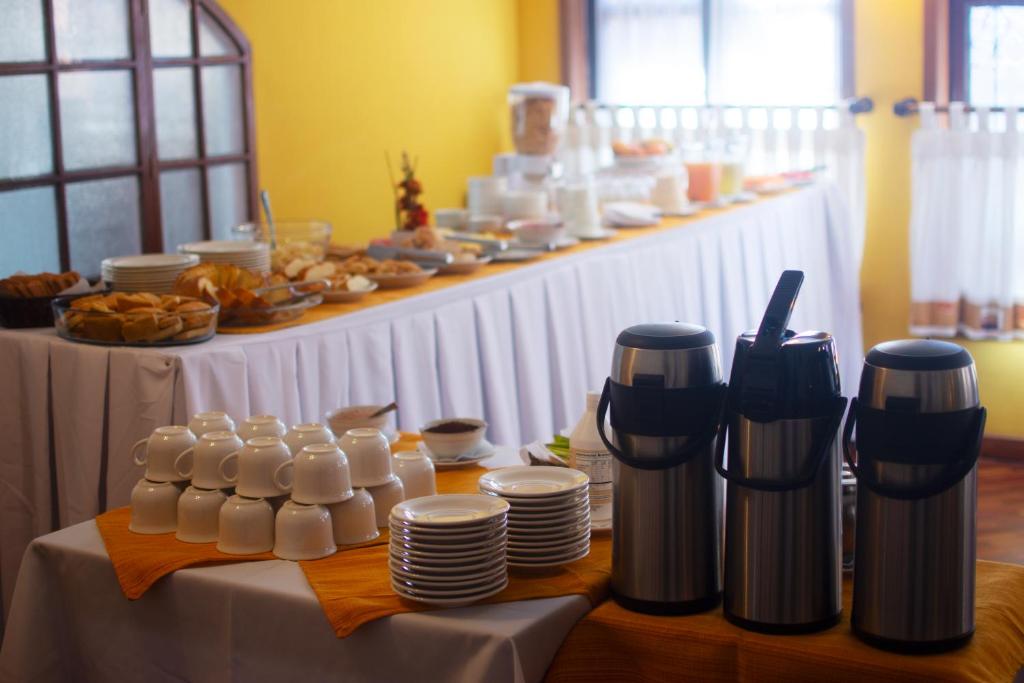 a table with plates and cups and food on it at Hotel Gran Libertador in Potosí