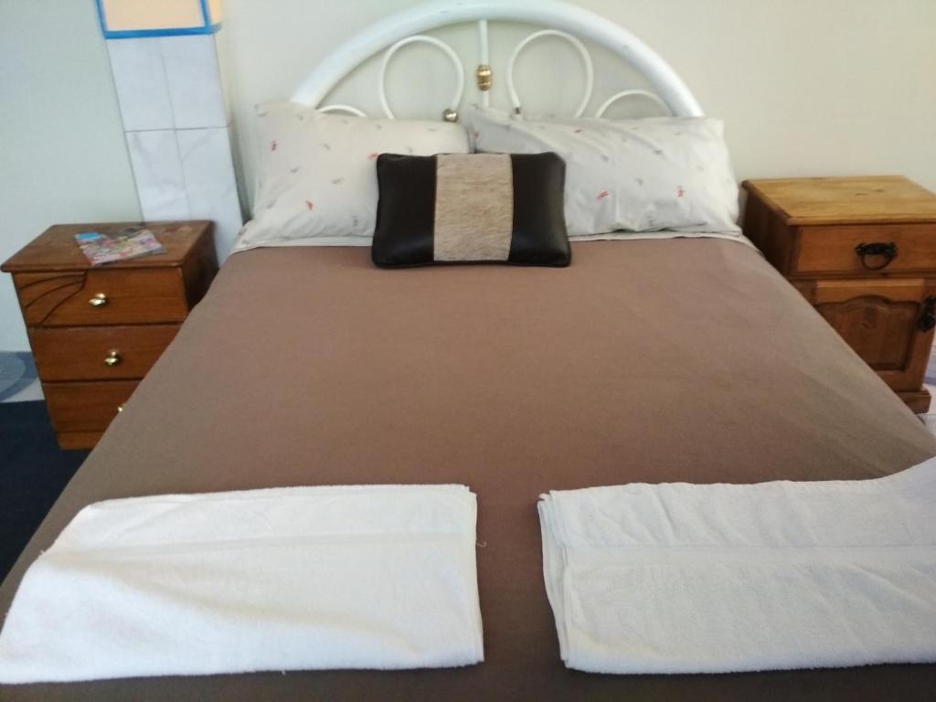 a bed with two white towels on top of it at habitación privada y confortable in La Paz