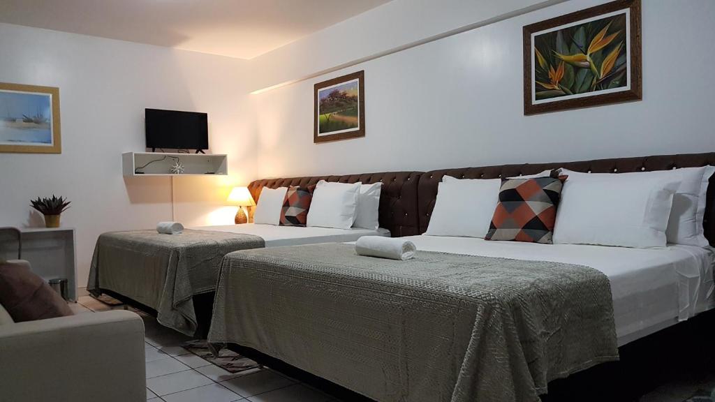 um quarto de hotel com duas camas e uma televisão em B & A Suites Inn Hotel - Quarto Luxo Palladium em Anápolis