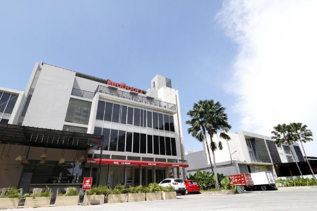 a building with a car parked in front of it at RedDoorz Plus @ Kapuk Business Park in Jakarta