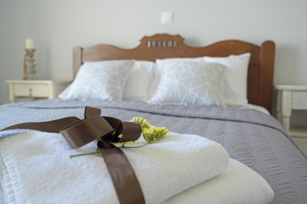 a bed with a brown ribbon and flowers on it at SgS Luxury Apartments in Xylokastron