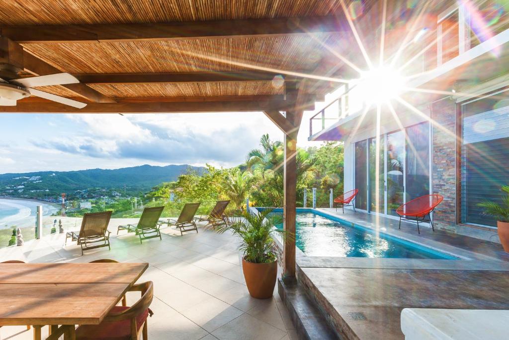 a patio with a table and chairs and a pool at Casa ChaChaCha in San Juan del Sur