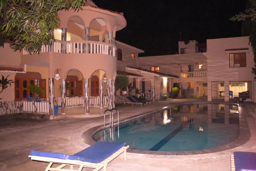 a swimming pool in front of a house at night at Leinmach House Nyali in Mombasa