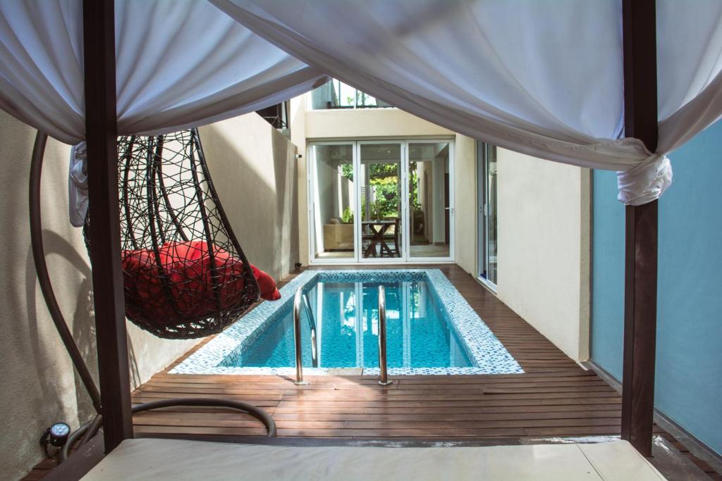 a swimming pool with a hammock next to a house at Kings Landing Unawatuna in Unawatuna