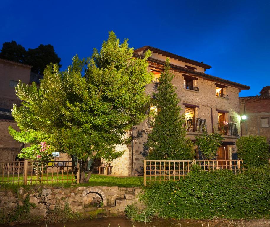 a large stone building with a tree in front of it at Hotel Rural Villa Liquidámbar in Torrecilla en Cameros