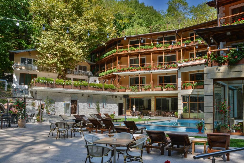 a hotel with a pool and tables and chairs at Hotel Saint Nedelya in Kolarovo
