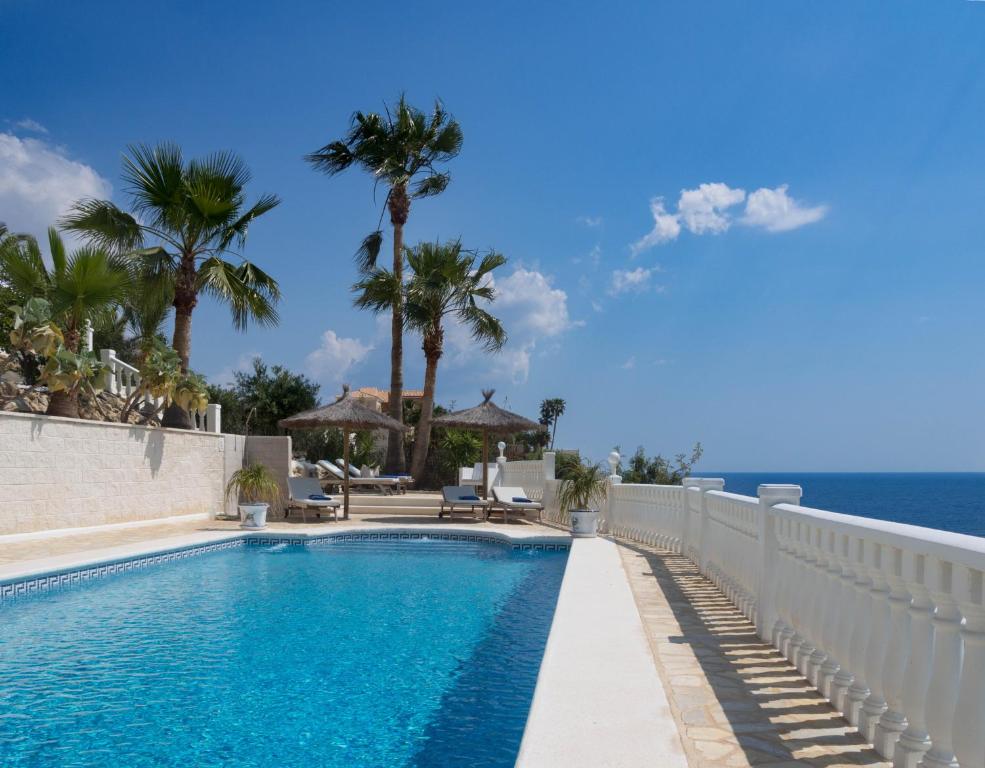 una piscina con el océano en el fondo en Frontline villa, five star deluxe, en El Campello