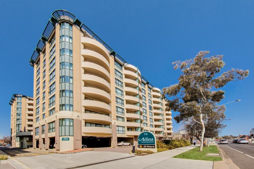 a tall building with a sign in front of it at Adina Serviced Apartments Canberra James Court in Canberra