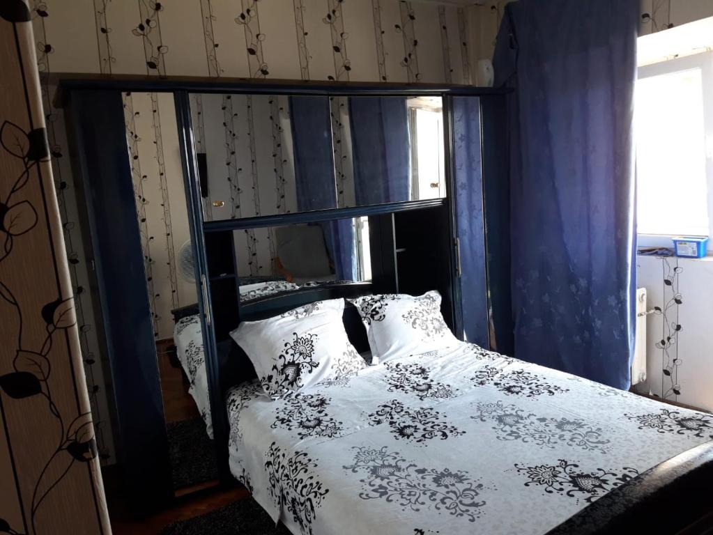 1 dormitorio con 1 cama con edredón blanco y negro en Hellen's Ultracentral Apartament en Buzau