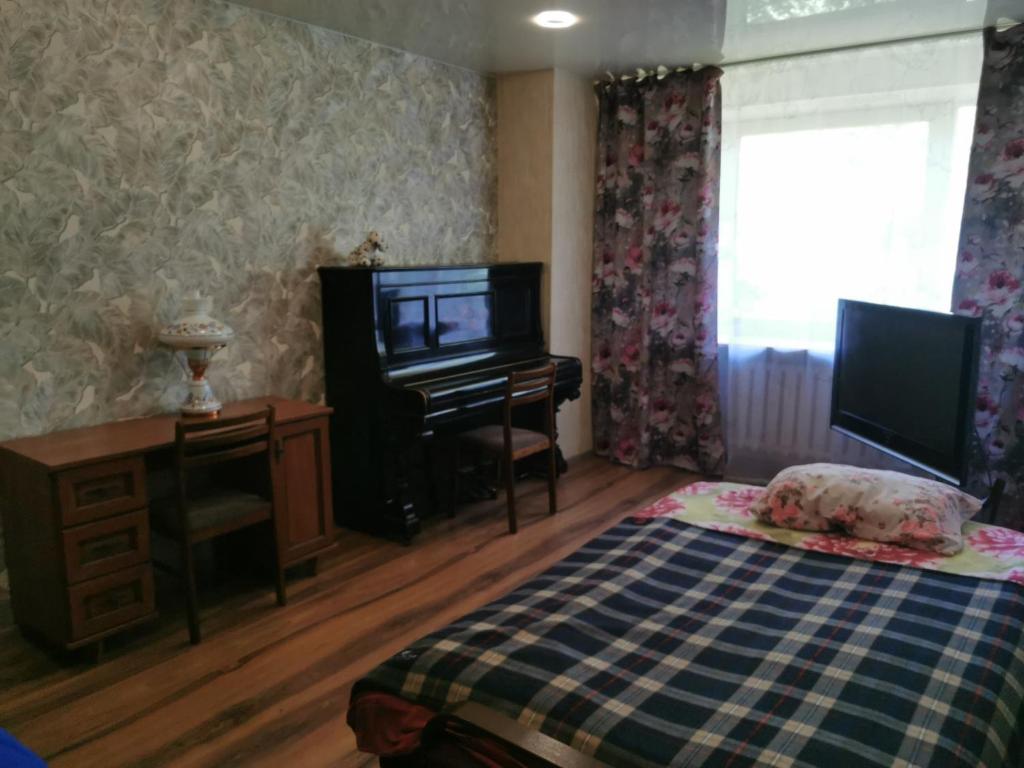 1 dormitorio con 1 cama, TV y escritorio en 12 Pargi, en Narva-Jõesuu