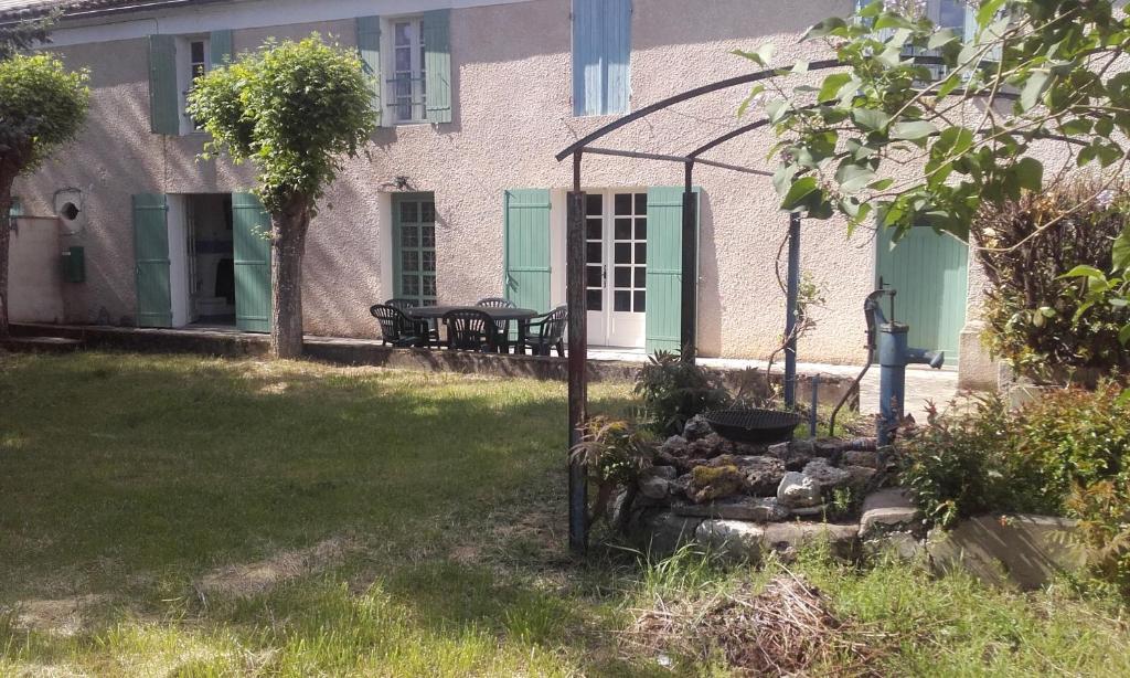 Casa con puertas verdes y patio con jardín de rocas en Le Grenouillet en Le Fleix