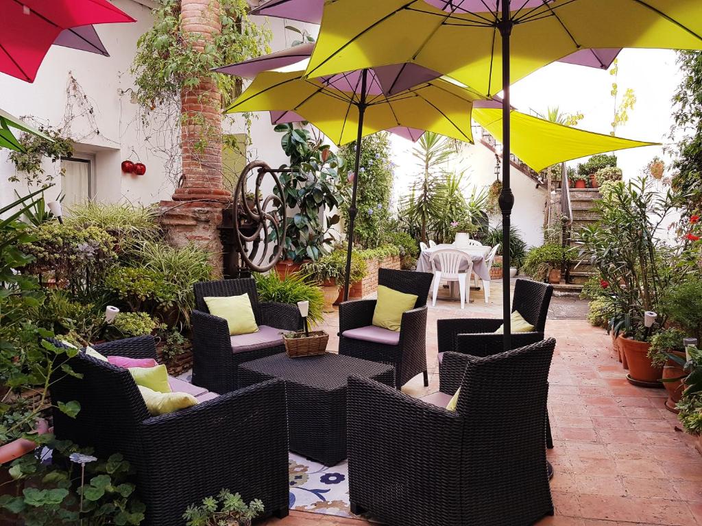 un patio con sillas y sombrillas en Le Presbytère, en Rivesaltes