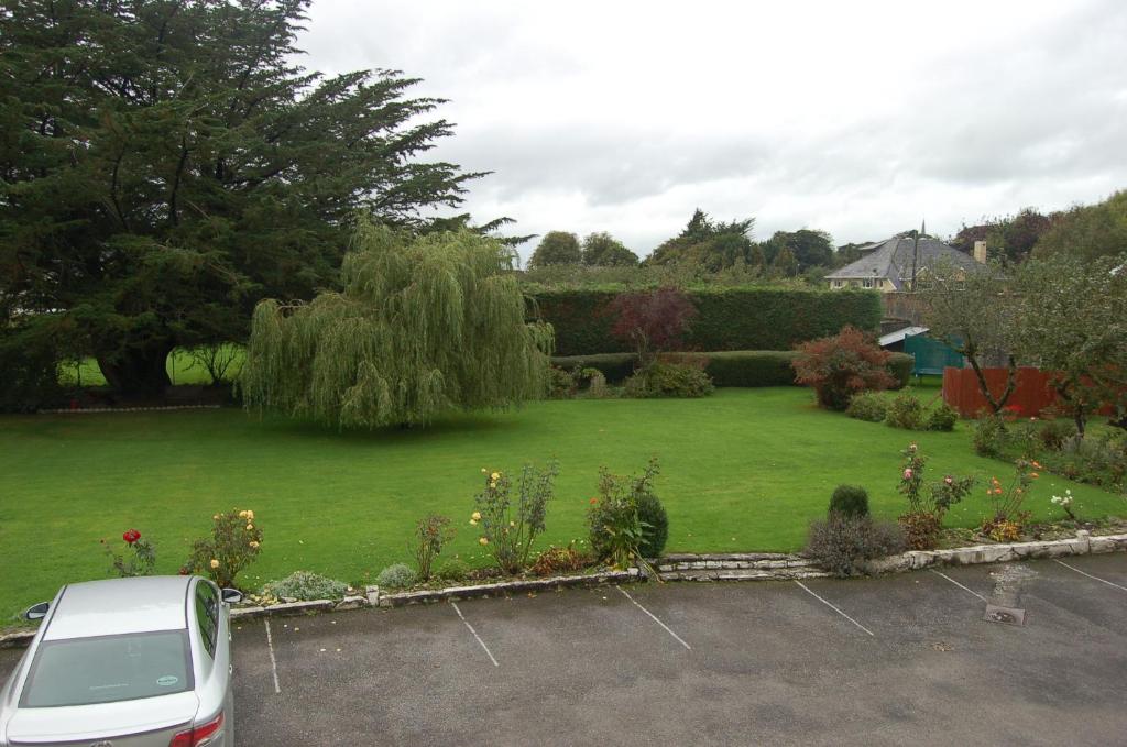 a car parked in a parking lot next to a garden at The Gardens guest accommodation in Killarney