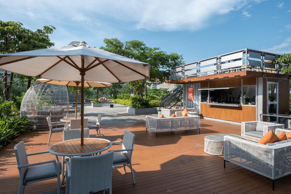 a patio with a table with an umbrella and chairs at HARRIS Resort Barelang Batam in Sagulung