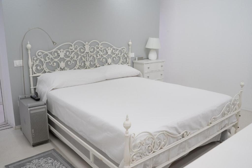 a white bedroom with a white bed with a white bed frame at Acquabianca in Aci Castello