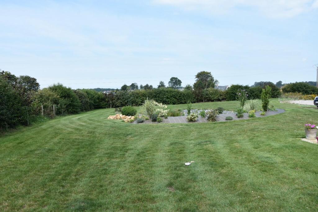 a field of grass with trees and bushes at Chambres d&#39;hôtes de L&#39;orval in Thiergeville