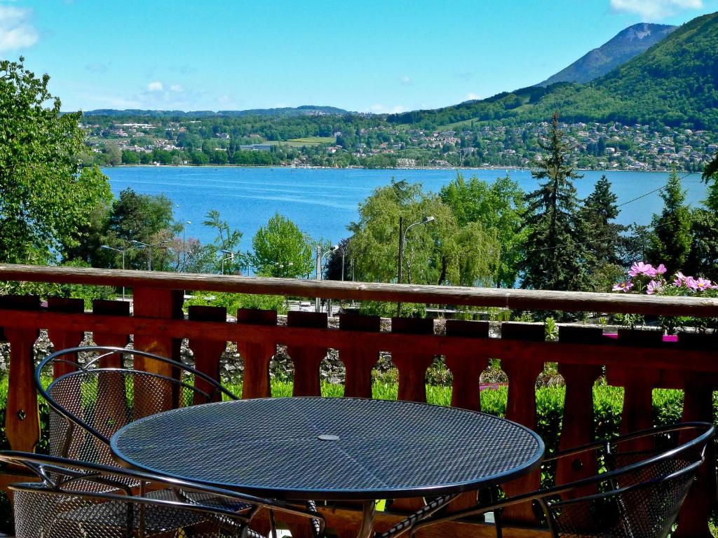 a table on a balcony with a view of a lake at Hotel des Marquisats in Annecy