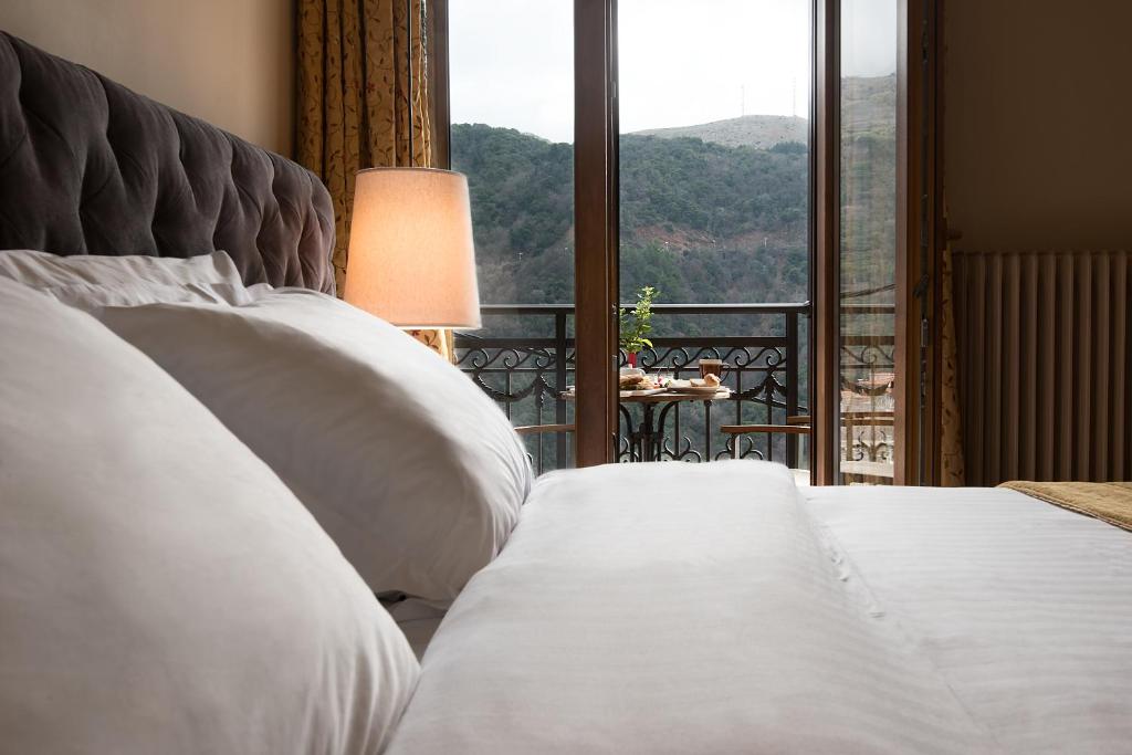 a bedroom with a bed and a window with a view at Kentrikon Hotel in Lagadia