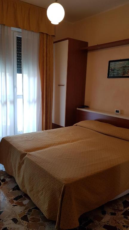 Un dormitorio con una cama grande y una ventana. en Albergo Ristorante Bergallo, en Tovo San Giacomo