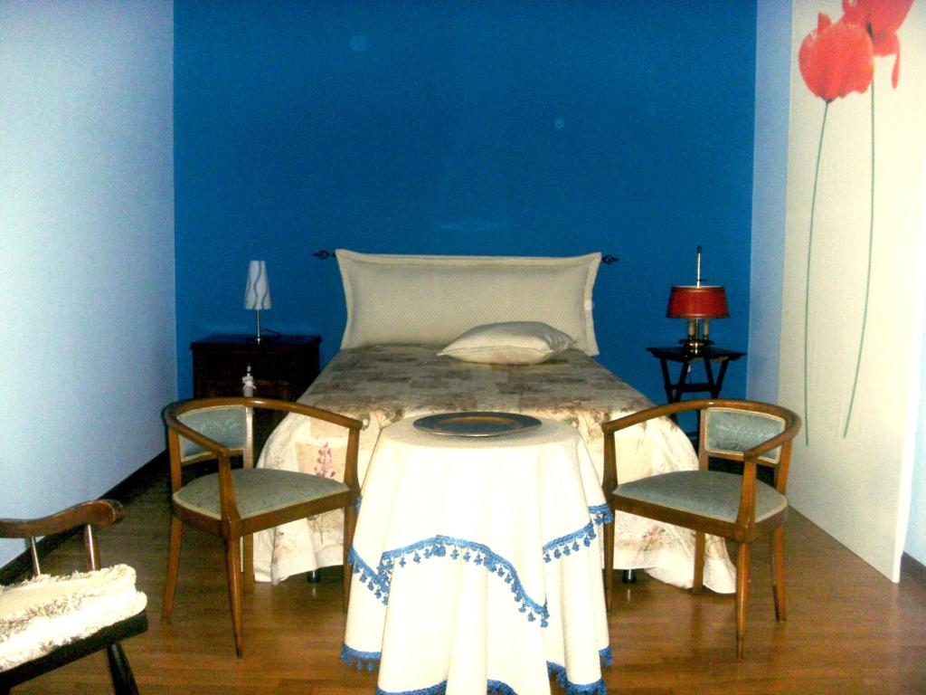 a bedroom with a bed with a table and two chairs at Le Vallonee B&B in Aradeo
