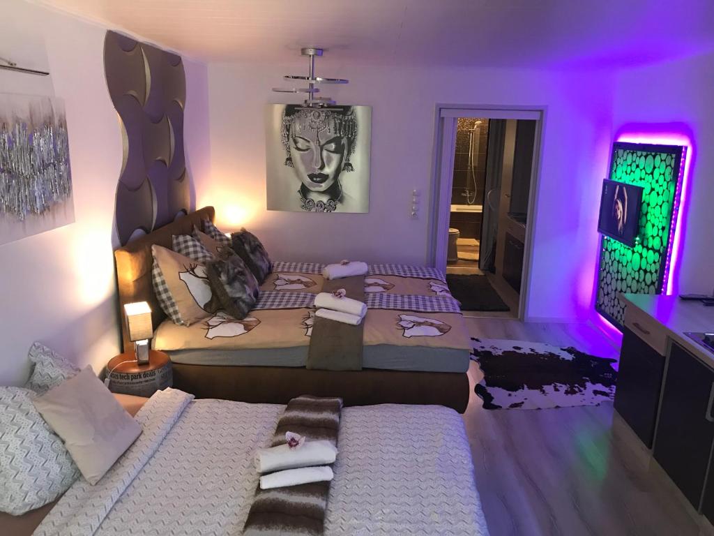 uma sala de estar com duas camas e iluminação roxa em EMERALD APARTMENT em Seefeld in Tirol