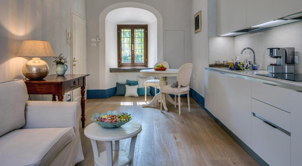 Il dispose d'une cuisine et d'un salon avec un canapé et une table. dans l'établissement Rambaldi Apartments Casa nr 1, à Bardolino