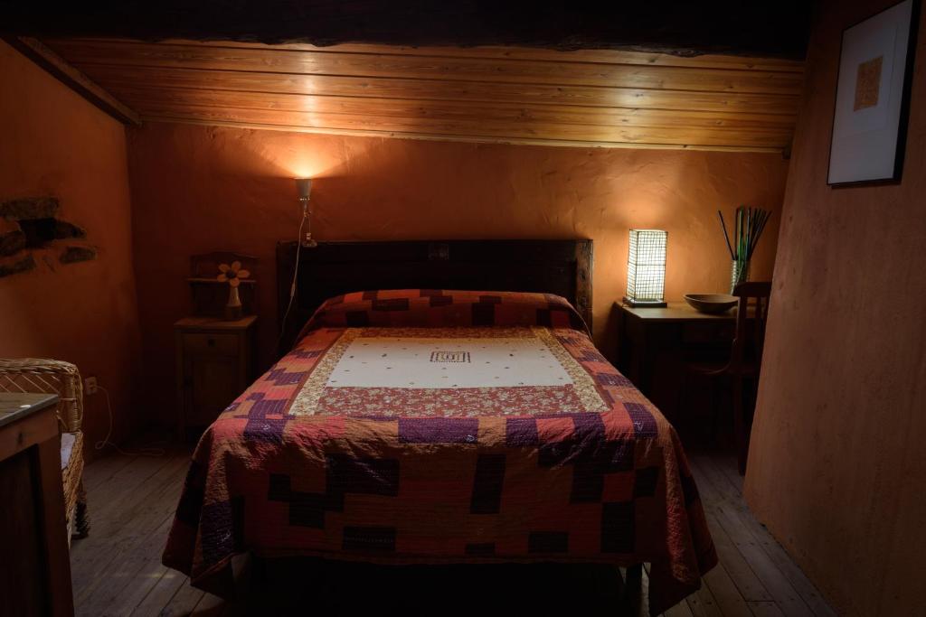 a bedroom with a bed with a quilt on it at Casa Rural Caenia Grupos in Traguntia