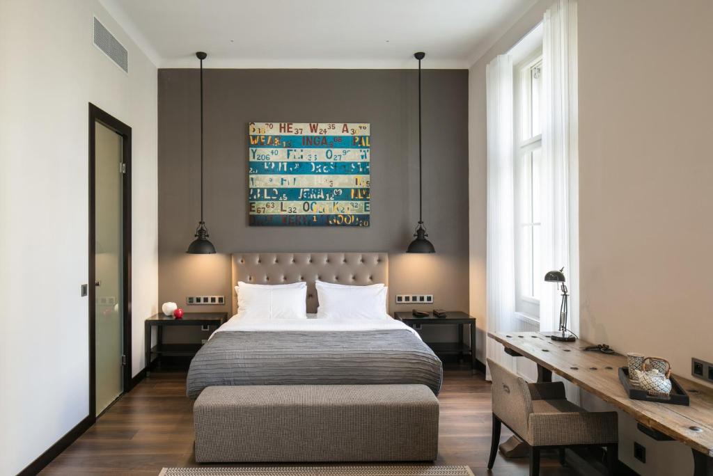 a bedroom with a large bed and a desk at Quentin Prague Hotel in Prague
