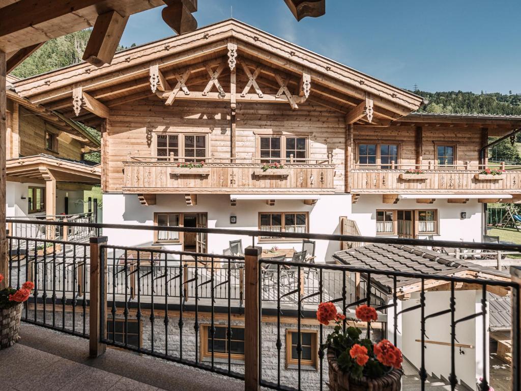 a wooden house with a balcony with flowers at Feriendorf Joggler - Chalets nahe der Gondel in Zell am Ziller