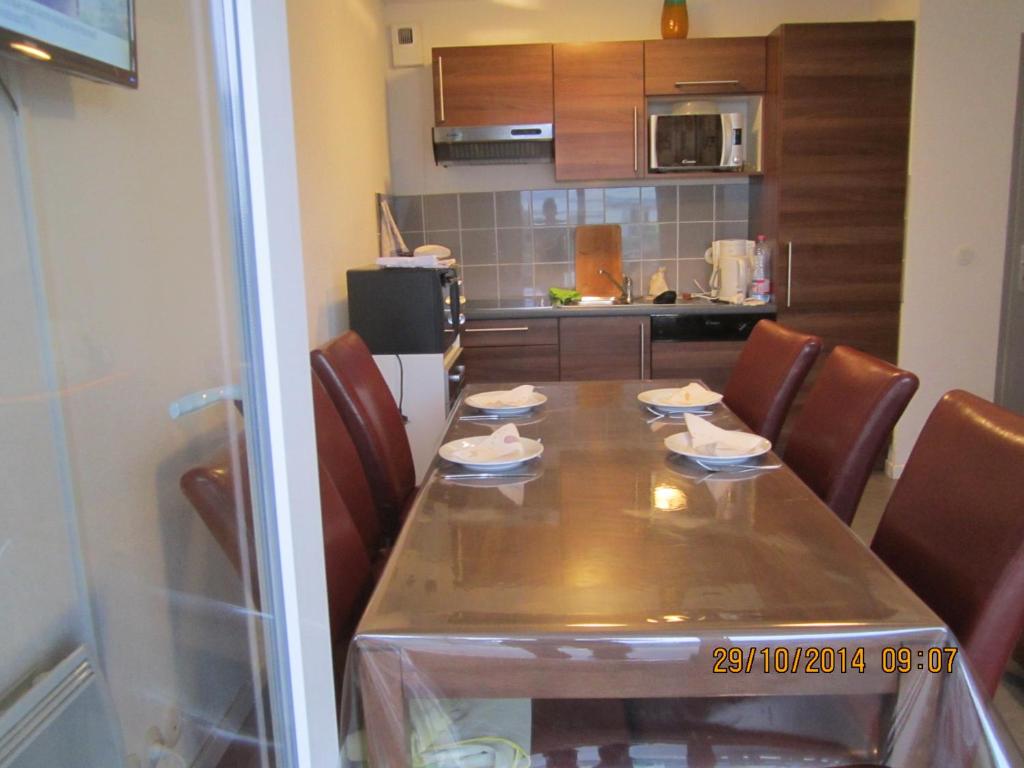 a dining room table with chairs and a kitchen at 206 aix les bains in Aix-les-Bains