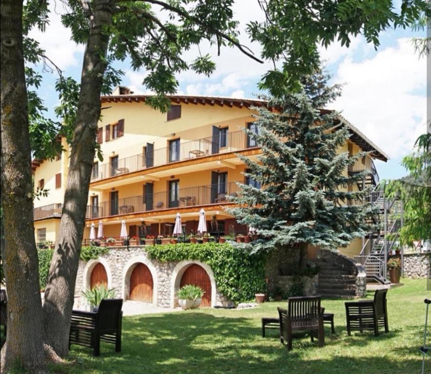 a large building with benches in a park at Hostal Cal Franciscó in Gósol