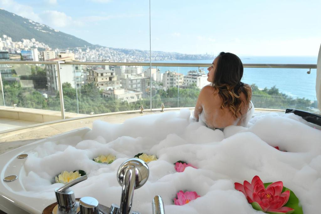 a woman sitting in a bathtub filled with foam at Hollywood Inn Boutique Hotel in Jounieh