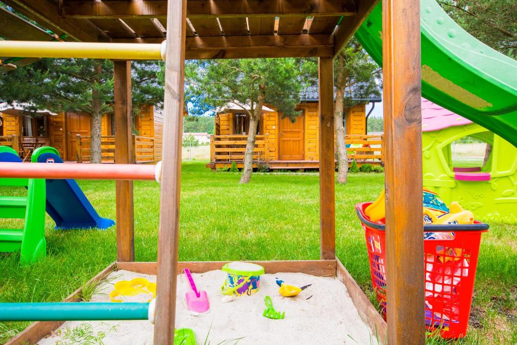a sandbox in the yard with toys in the sand at domki letniskowe Ustka Sosnowo in Ustka
