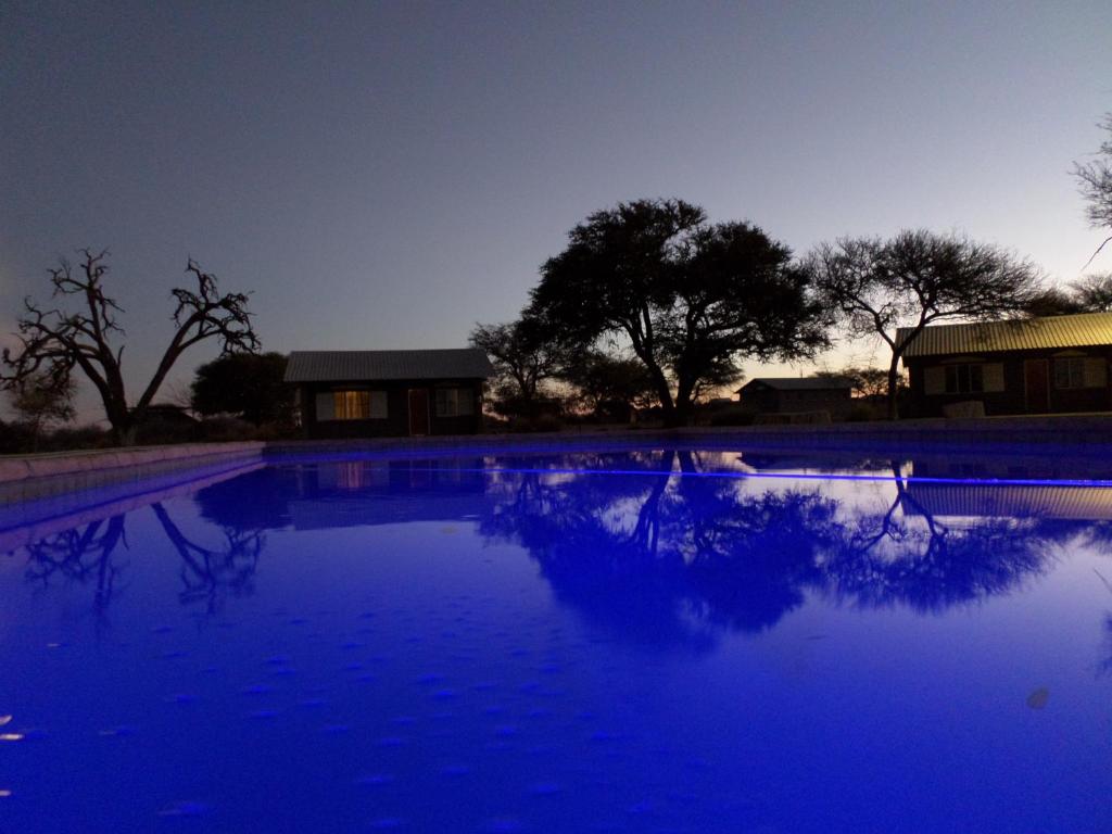 a pool of blue water in front of a building at Out Of Nature Country Lodge in Windhoek