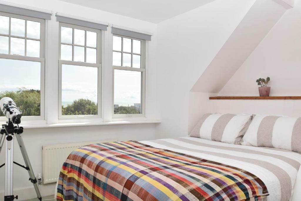 1 dormitorio con 1 cama con una cámara en un trípode en Coastguard's Cottage en Pett