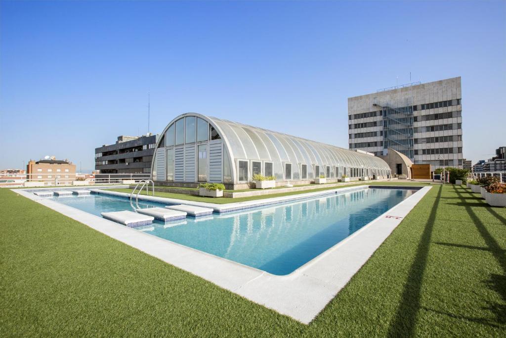 una piscina frente a un edificio en Pierre & Vacances Apartamentos Edificio Eurobuilding 2 en Madrid