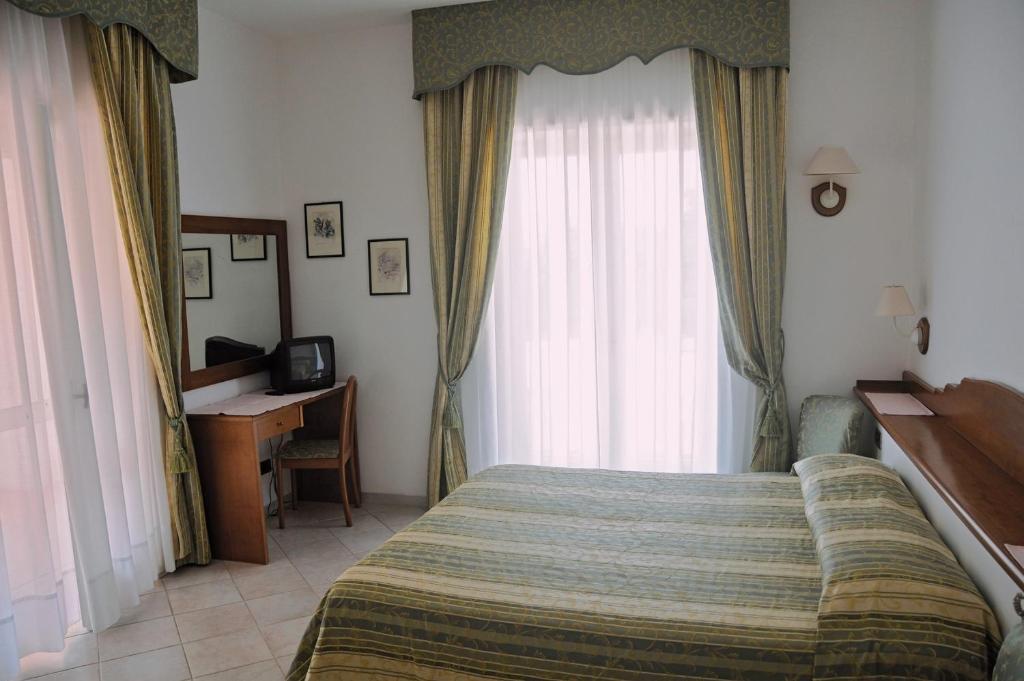 Postel nebo postele na pokoji v ubytování Hotel Biancamaria
