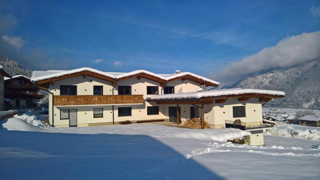 ein Haus mit Schnee auf dem Boden davor in der Unterkunft Apart Andreas in Ried im Zillertal