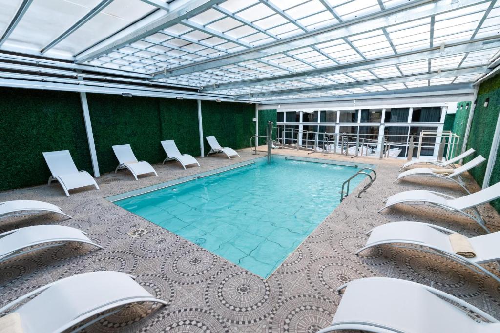 a large swimming pool with chairs and a swimming poolvisor at Ker San Telmo Hotel in Buenos Aires