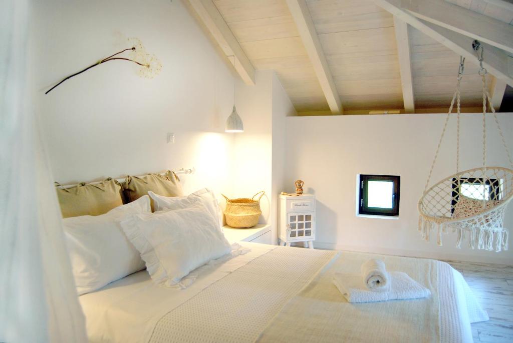 a bedroom with a white bed with a towel on it at To Spiti - Pelion House in Kala Nera